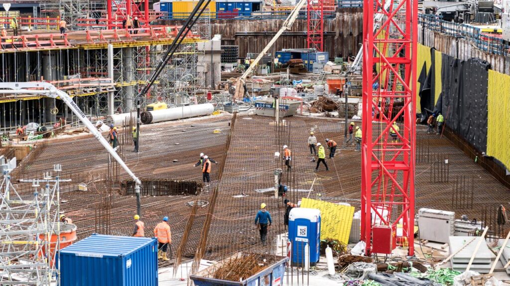 A bustling construction site in Hamburg with workers and equipment actively engaged in building tasks.